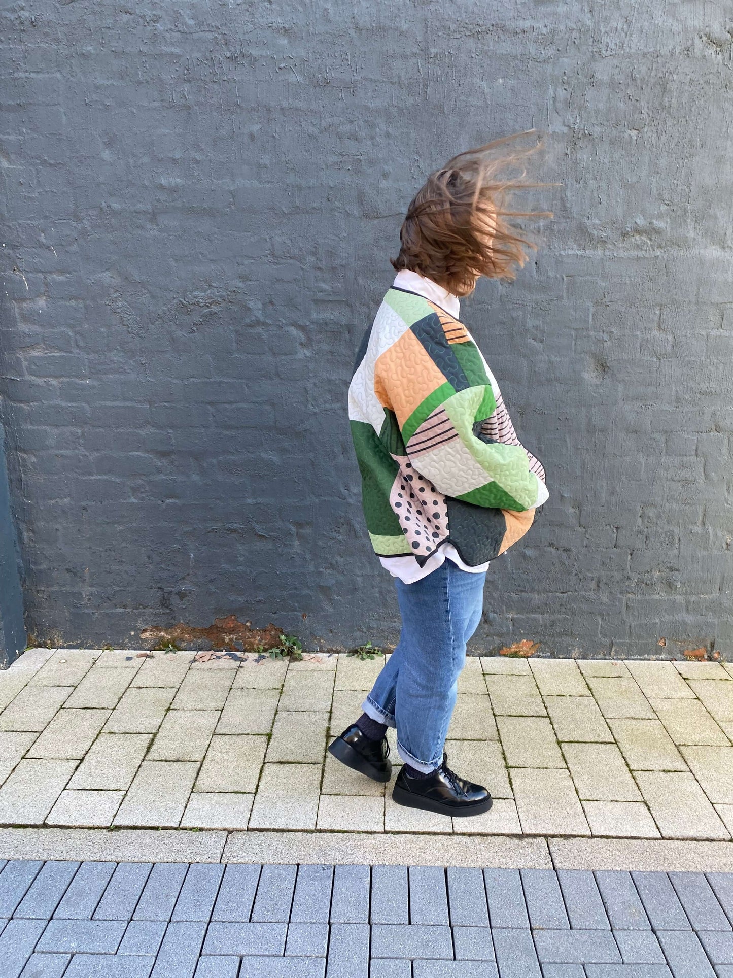 Model wearing Christine Jacket, a quilted oversized fit with patchwork design, made from recycled blanket fabric.