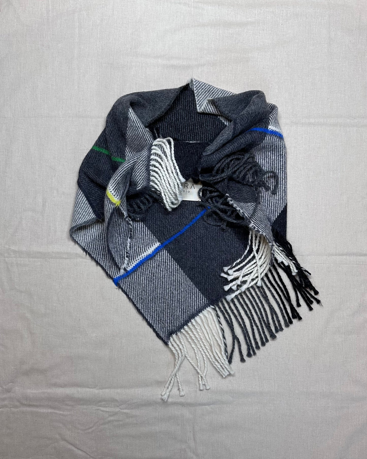 Plaid scarf with fringe on a gray background