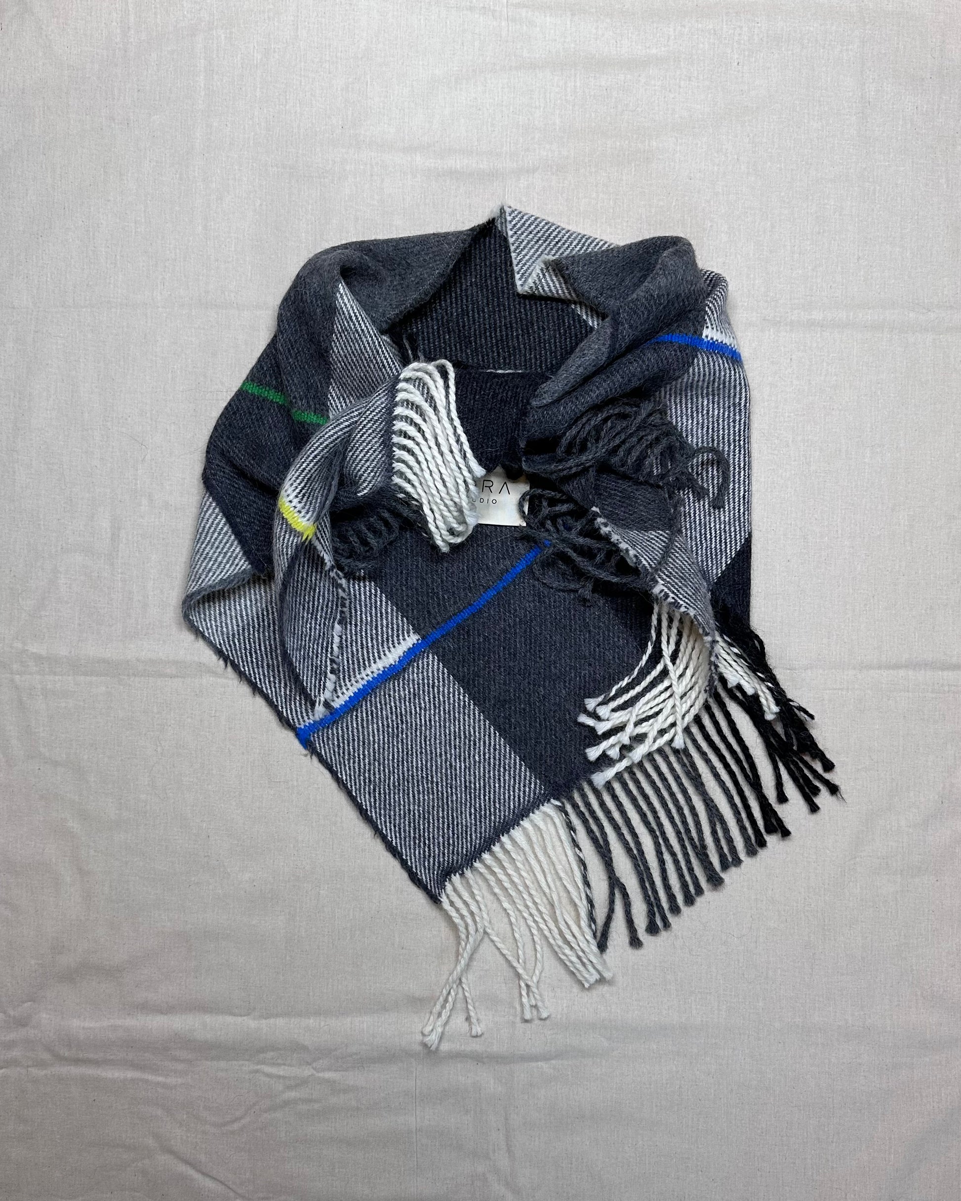 Plaid scarf with fringe on a gray background
