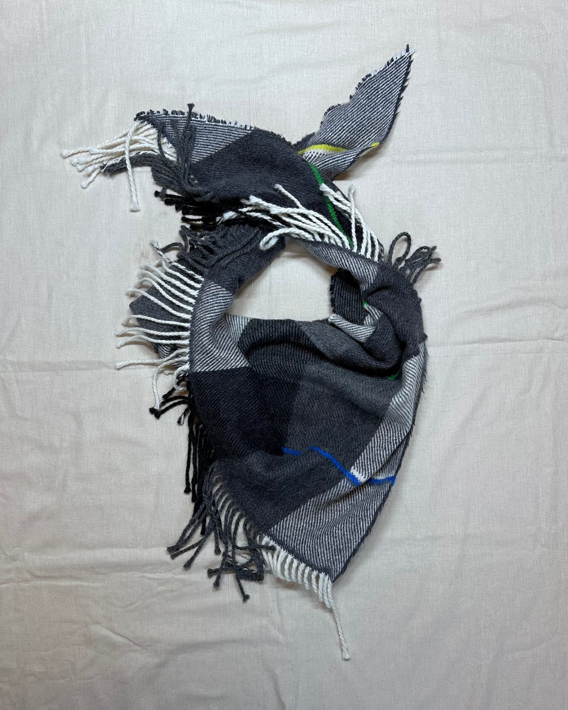 Plaid scarf with fringes on a light gray background