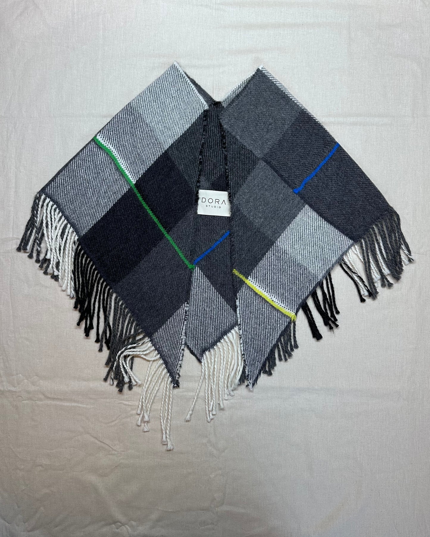 Plaid triangle scarf with fringes on a light background